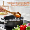 Wooden slotted spoon holding an egg over a pot of boiling water.