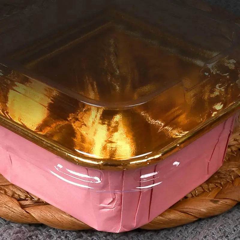 Shiny gold-topped pink box.