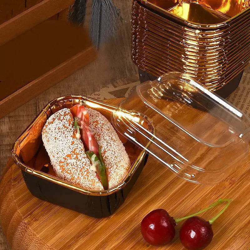 Sandwich in a black and gold container with a clear lid.