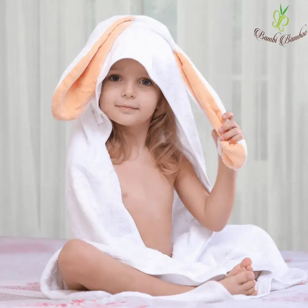 Happy child snuggled in an Amber Bunny Hooded Towel after bath time fun