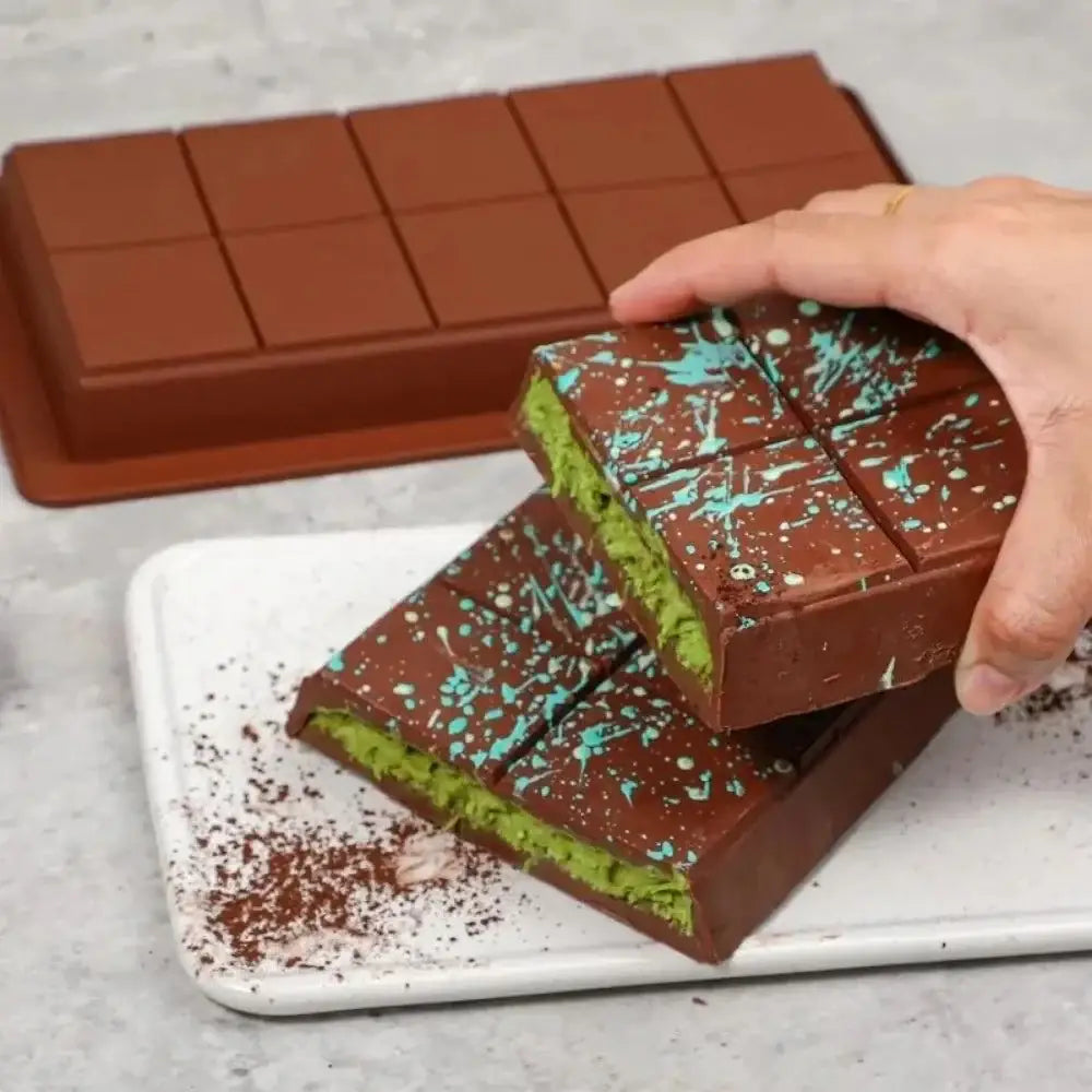 Chocolate bars with green filling and blue sprinkles made using silicone chocolate bar molds