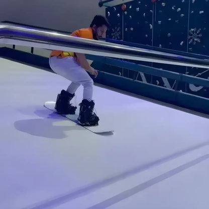 Snowboarder shredding on the Tuocen Professional Alpine Ski Machine indoors