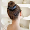 Dark, patterned hair clip holding a bun.