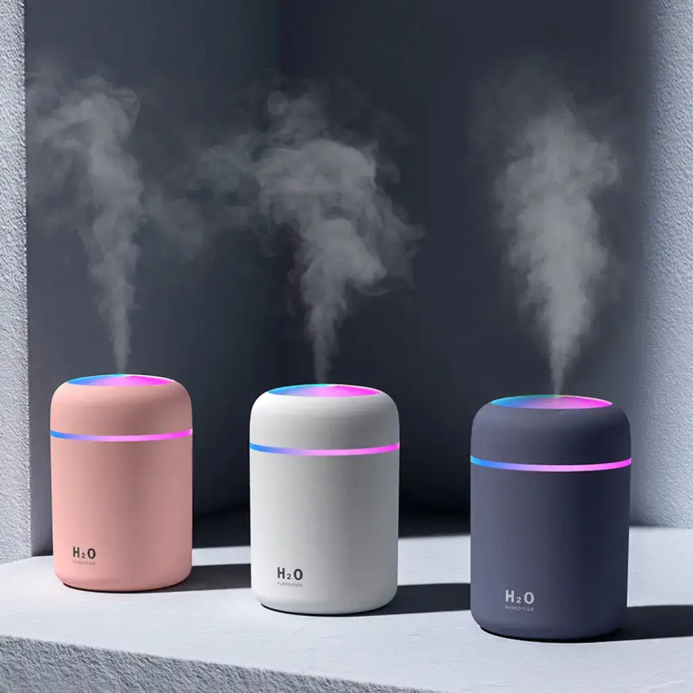 Three colorful Portable Air Humidifiers emitting vapor as essential oil diffusers