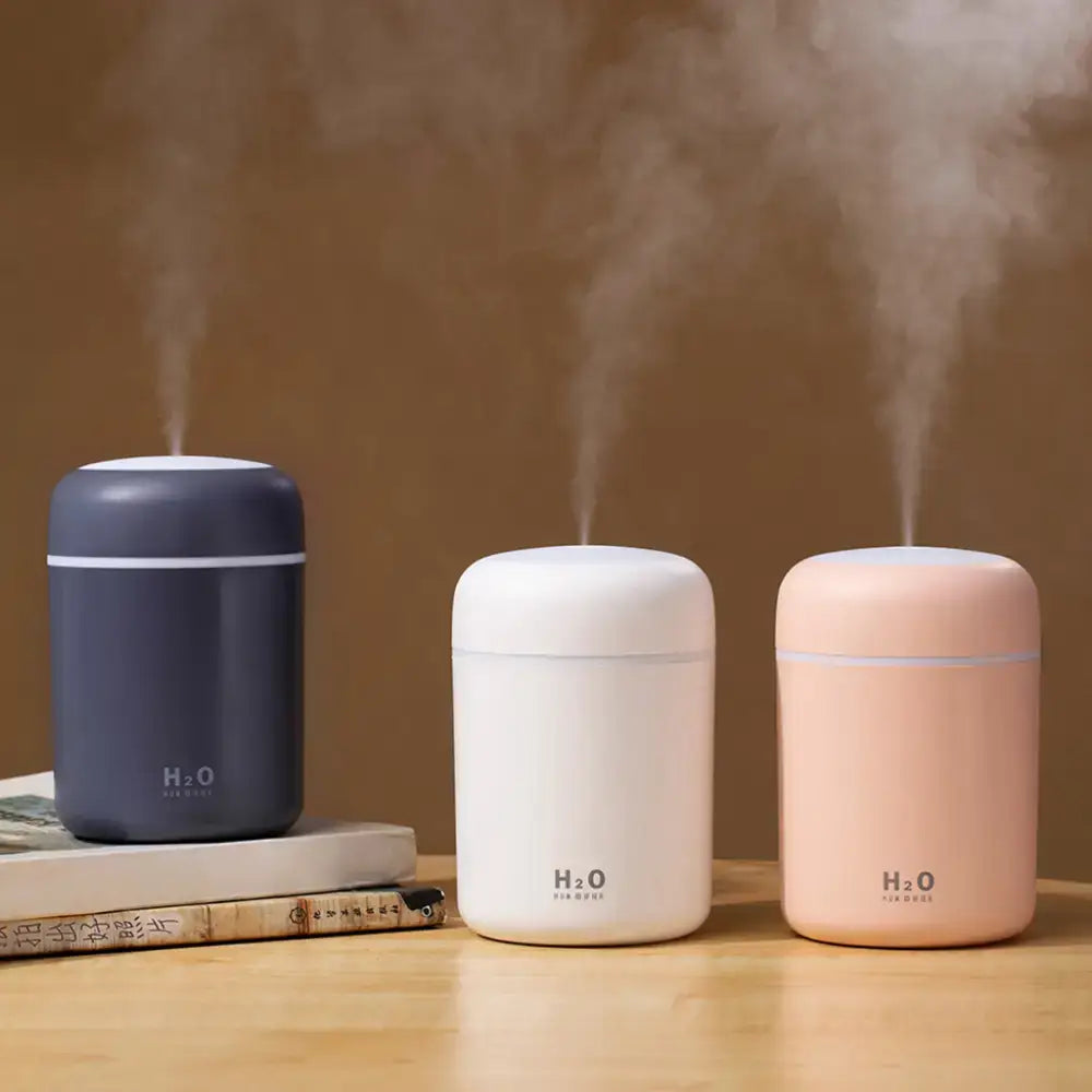 Three colorful portable air humidifiers emitting vapor, perfect as essential oil diffusers