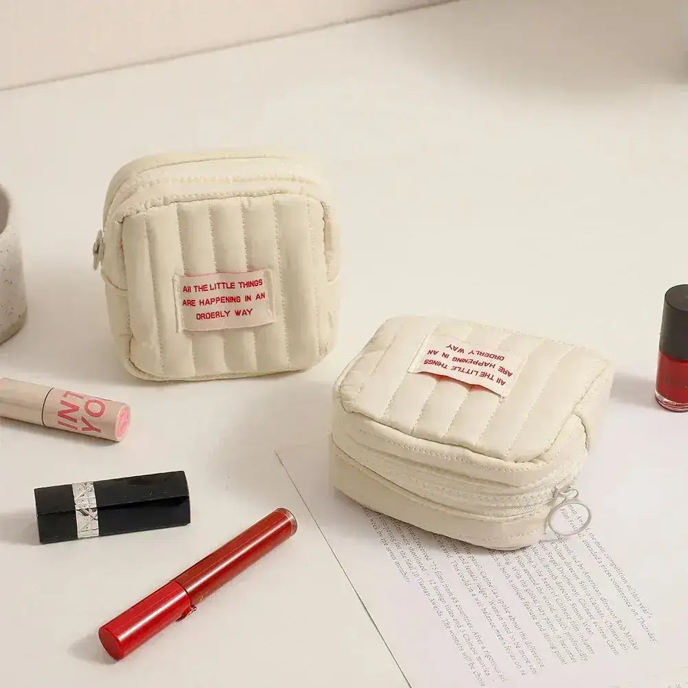 Two cream-colored, quilted Korean square small makeup bags for stylish organization