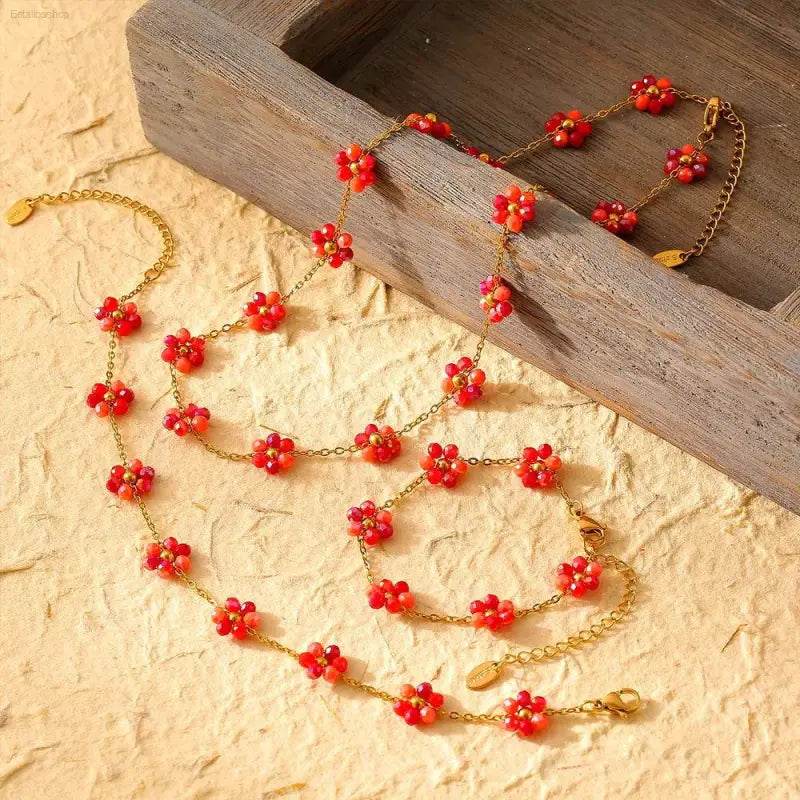 Gold chain jewelry with red flower beads.