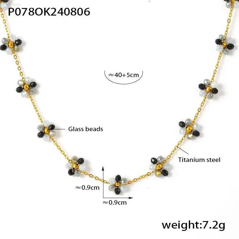 Gold-toned necklace with flower-shaped glass bead accents.