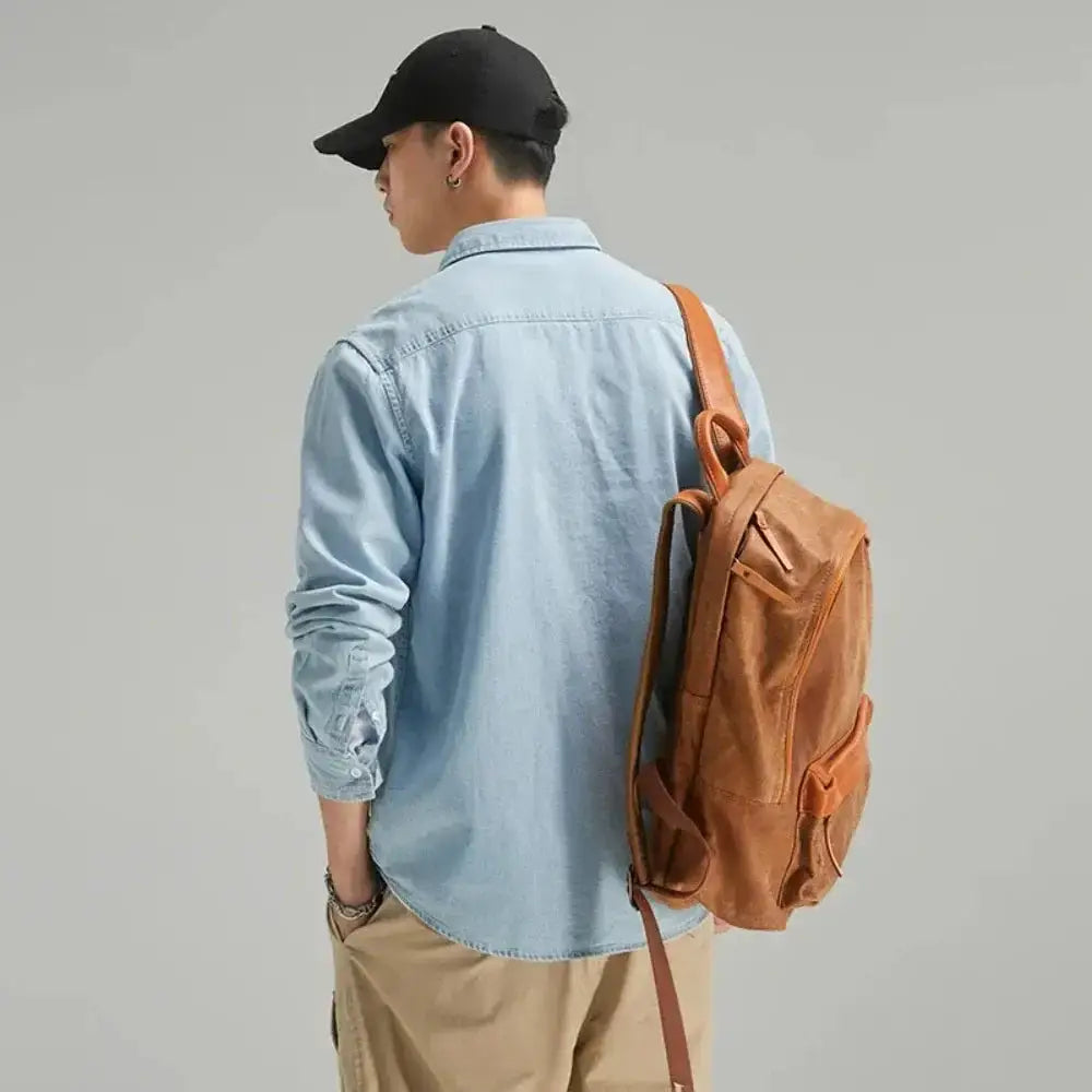 Brown leather backpack paired with a stylish denim shirt for a trendy look