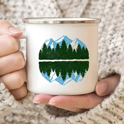 White enamel mug featuring a mountain and forest design for wanderlust camping adventures