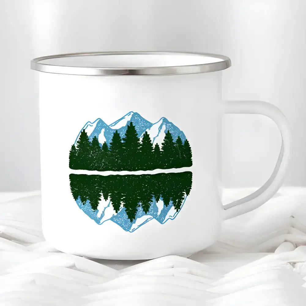 White enamel mug featuring a mountain and forest design for wanderlust camping lovers