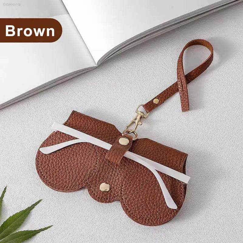 Brown leather glasses case with strap.