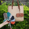 Beige tote bag with colorful eyewear cases.