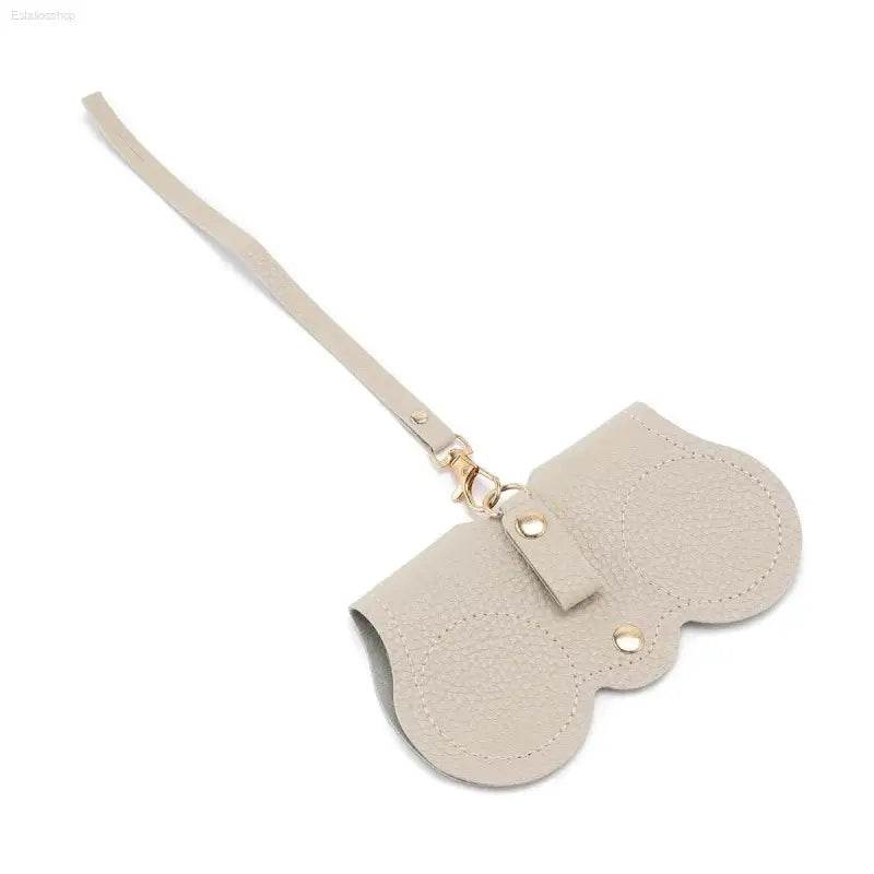 Beige leather case with strap.