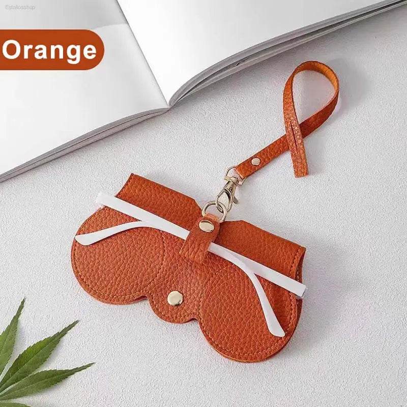 Orange leather glasses case with strap.