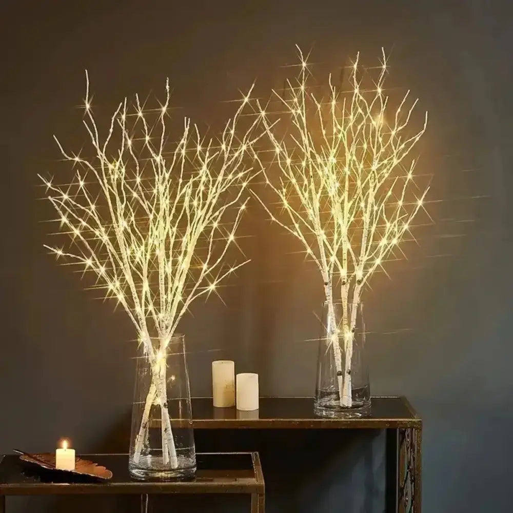 Illuminated white birch branch lights in stylish vases for a cozy vibe