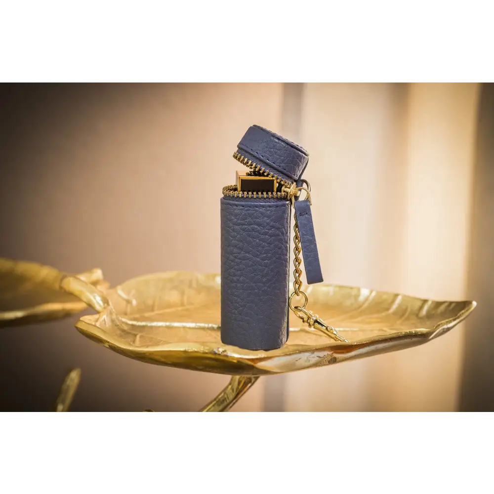 Blue leather lighter case with gold zipper, a stylish lipstick keeper in pebble leather