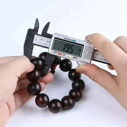 Wooden bead bracelet being measured with digital display caliper for precise dimensions