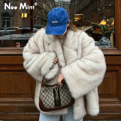 Woman in a gray gradient coat, stylishly rocking a Gucci handbag and faux fur vibes