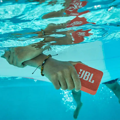 Bright orange JBL GO2 IPX7 waterproof wireless speaker in action