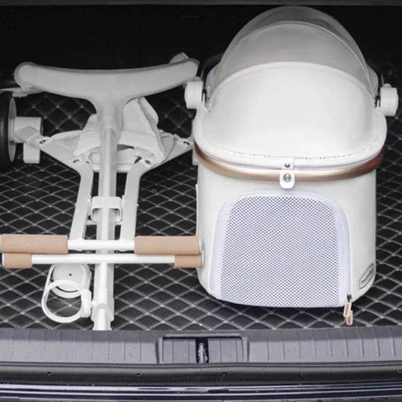 Folded white stroller with tan accents.