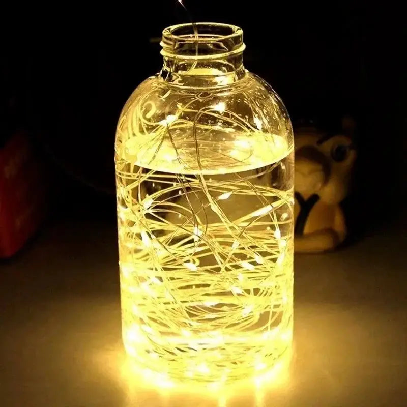 Illuminated glass bottle with USB LED string and silver wire garland lights inside