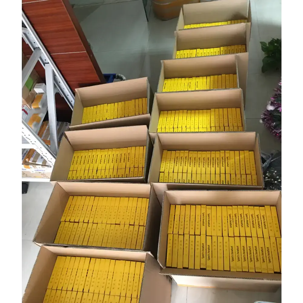 Boxes filled with yellow packages of Magnetic Sport Earbuds with ergonomic design