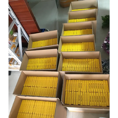 Boxes filled with yellow packages of Magnetic Sport Earbuds with ergonomic design