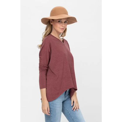 Woman in a brown hat wearing a dolman sleeve oversized knit tunic blouse