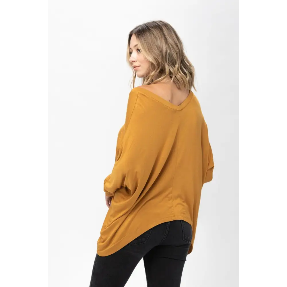 Woman in mustard v-neck sweater and black pants showcasing Dolman Sleeve Oversized Knit Tunic Blouse