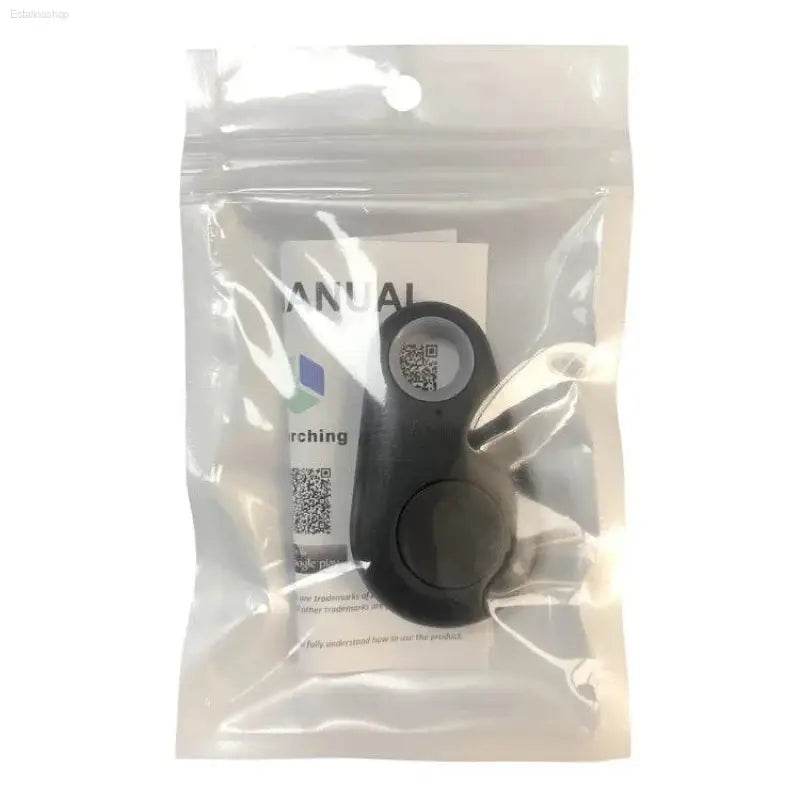 Black, circular, electronic tracker in packaging.