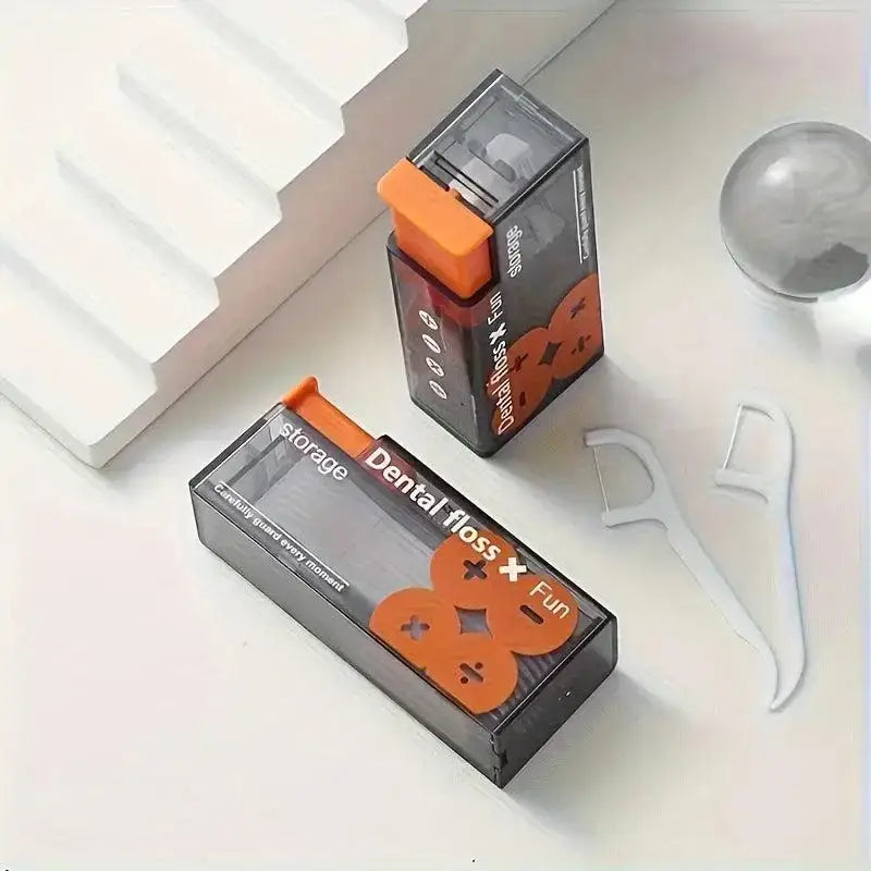 Dental floss containers with orange accents in a Portable Floss Dispenser Kit