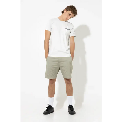 Man in a white sold classic unisex t-shirt and khaki shorts showcasing Swedish attitude