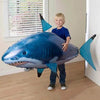 Boy holding inflatable shark toy.