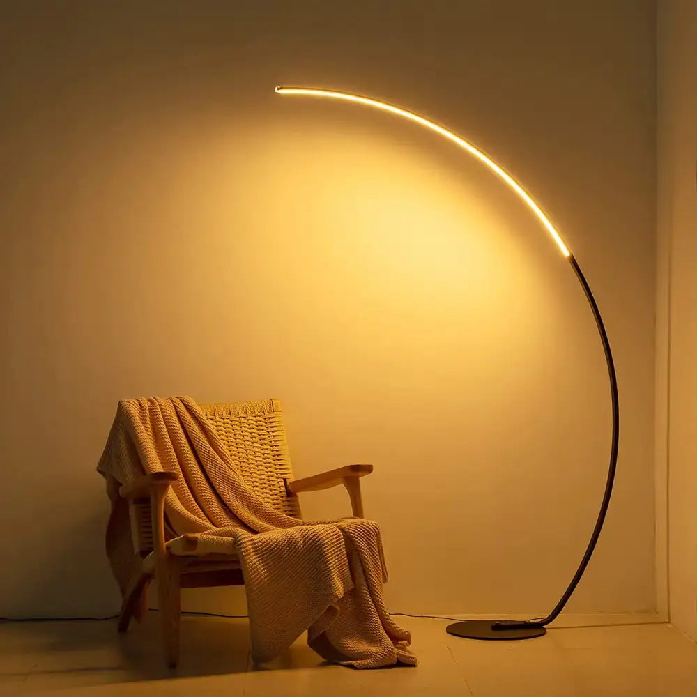 RGBW Modern Curve Floor Lamp brightening up a cozy chair in a stylish setting