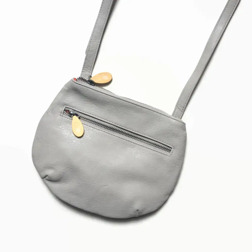 Gray leather Willoughby Crossbody Bag with wooden zipper pulls, stylish and functional