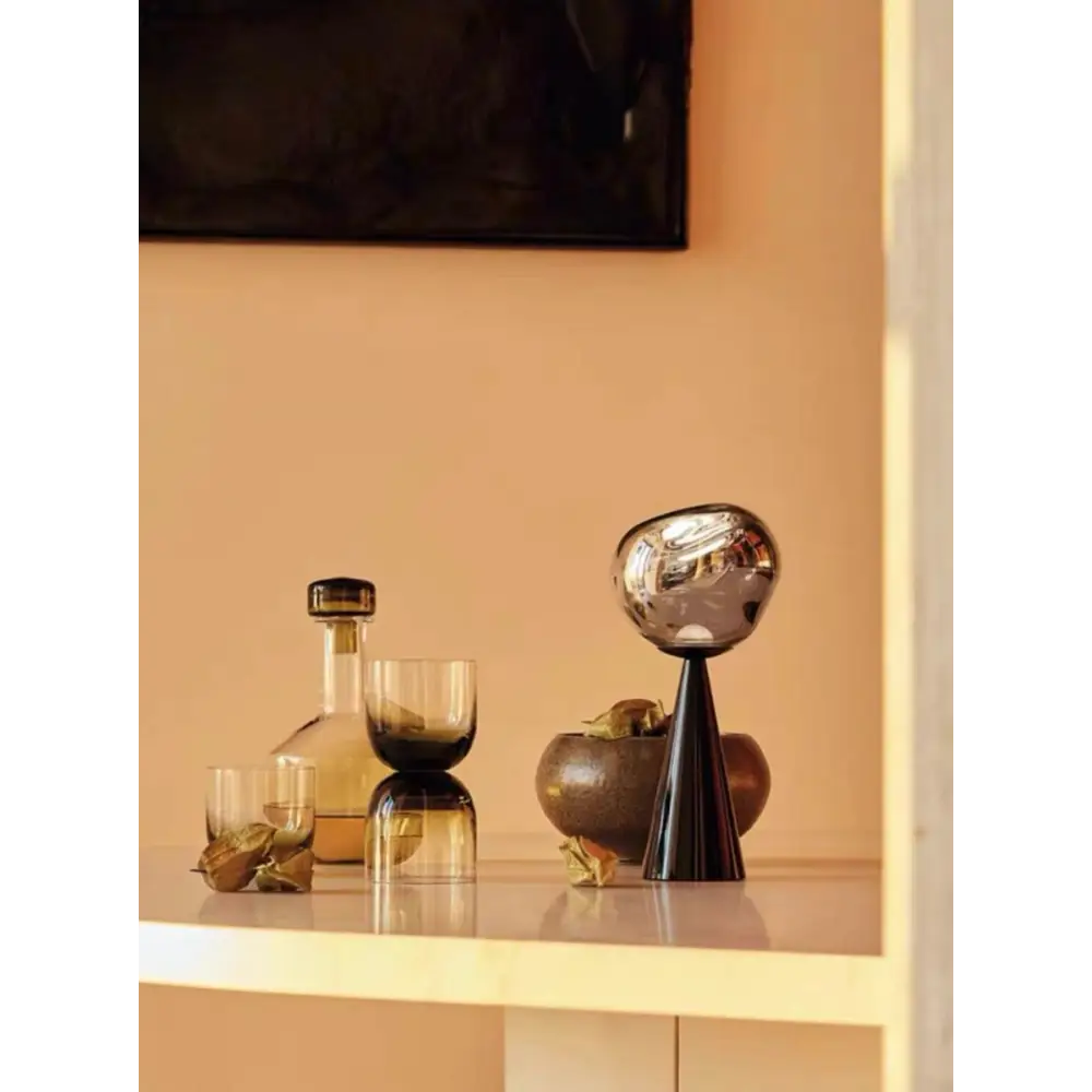 Decorative silver orb atop a sleek black cone in a modern table lamp design