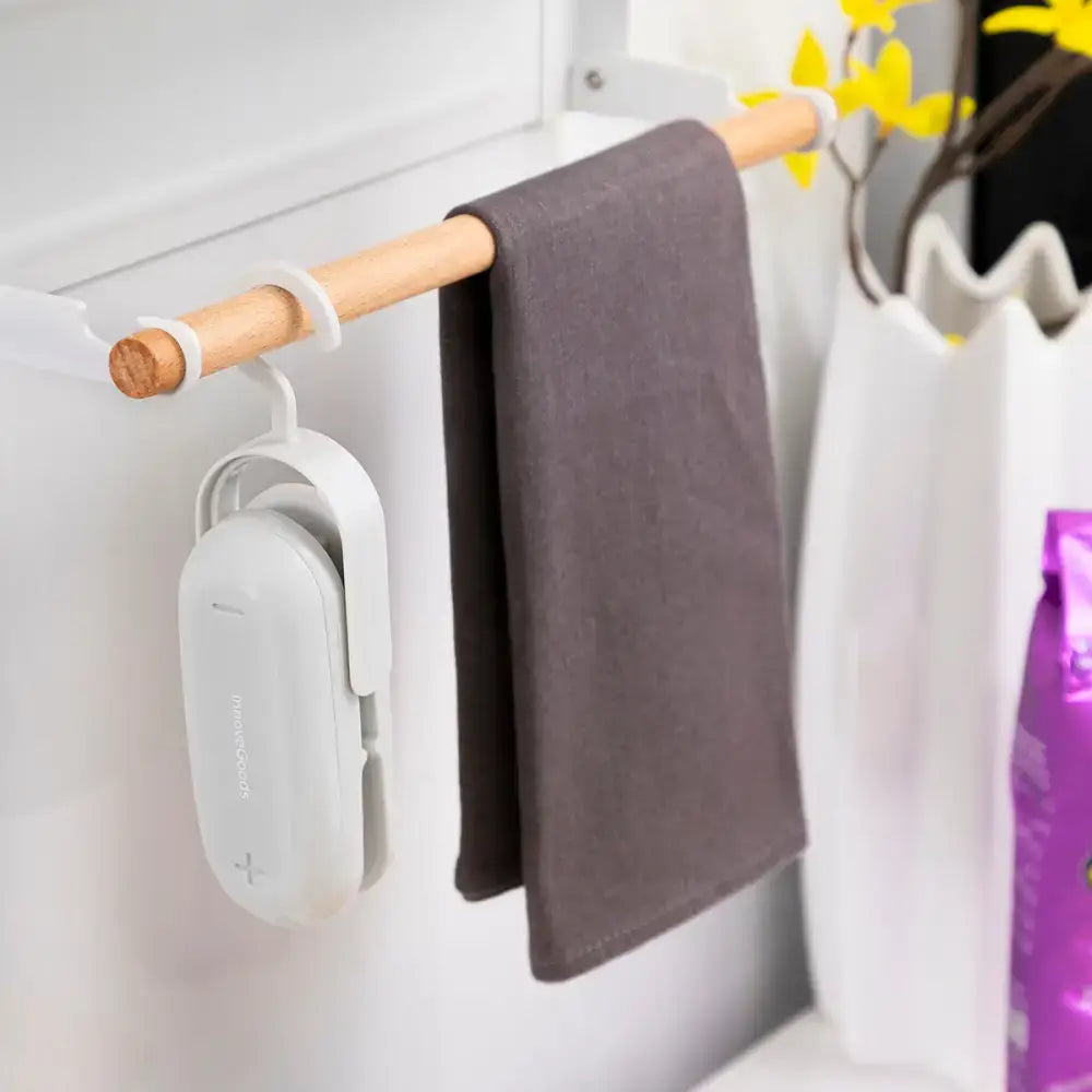 Gray towel hanging on a wooden rod with Baseyl Innovagoods Bag Sealer