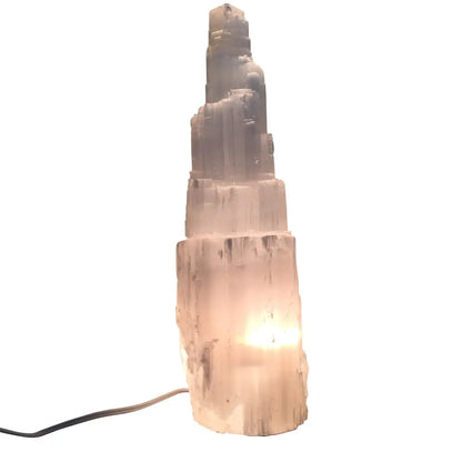 Illuminated Selenite Crystal Skyscraper Lamp Prime shining bright in a cozy space