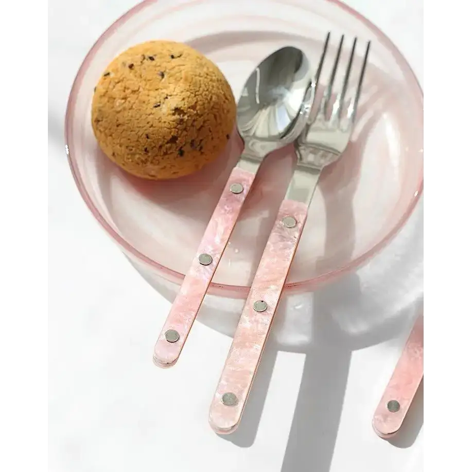 Pink-handled silverware on a plate showcasing the sleek modern pinky flatware set