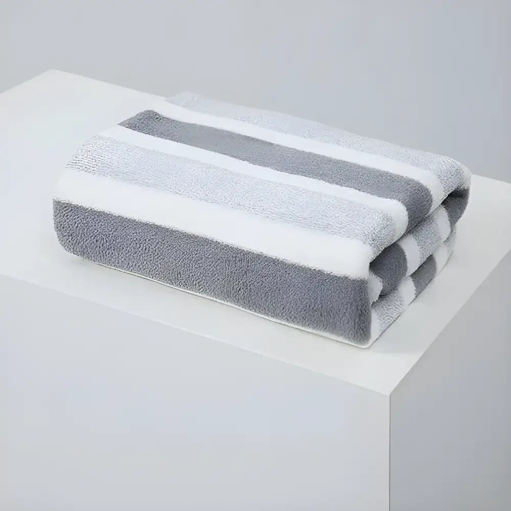 Folded gray and white striped towel, perfect soft absorbent bath towel for your bathroom