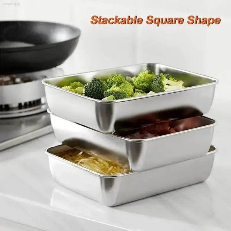 Stacked square stainless steel food containers.