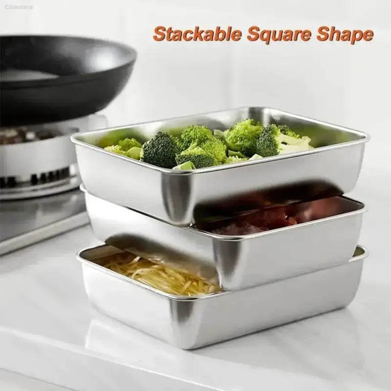 Stacked square stainless steel food containers.