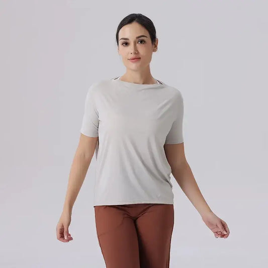 Woman in light gray t-shirt and brown pants, showing off Ice Silk Breathable Yoga Clothes Loose Quick design