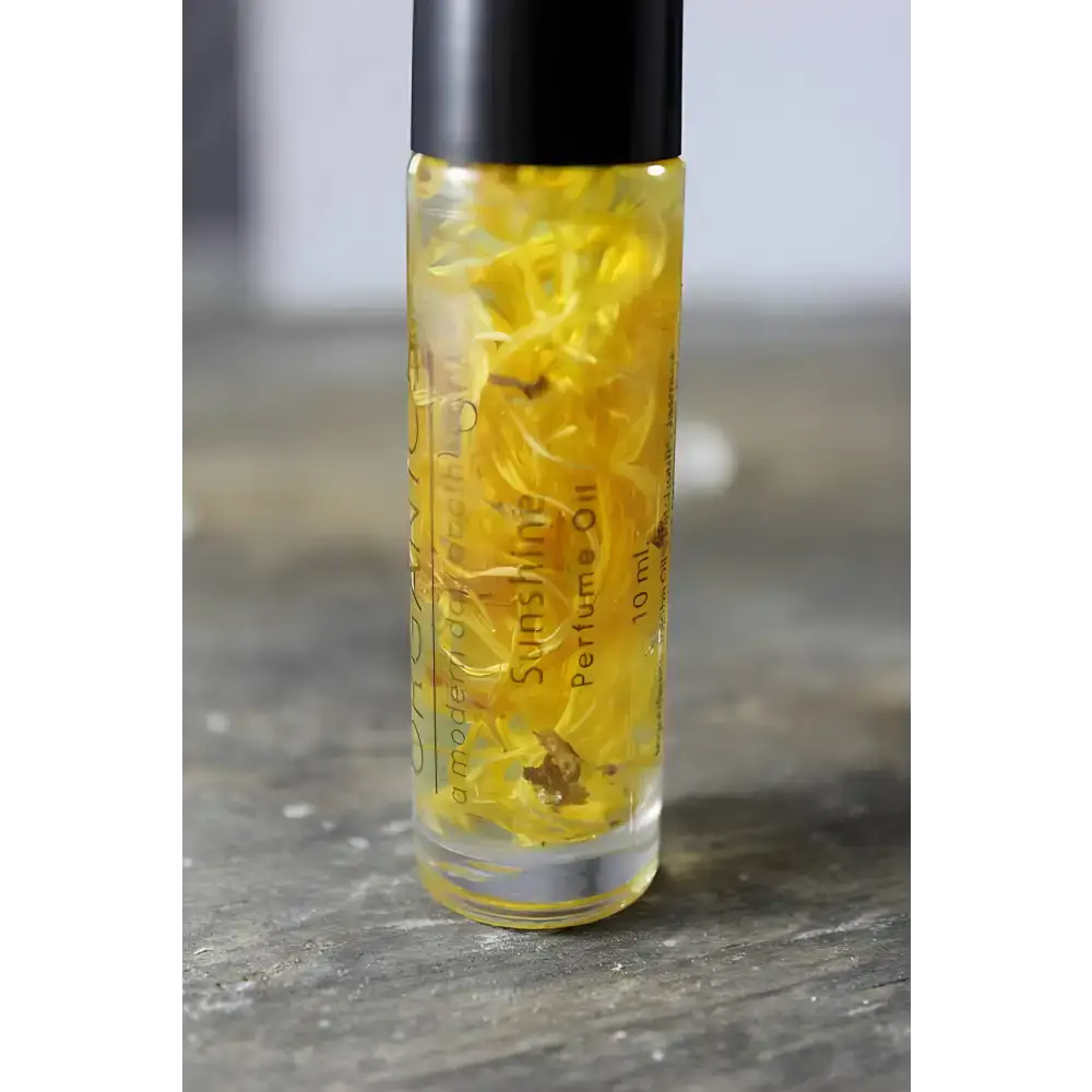 Sunny Flower Petal Perfume Oil in a clear bottle with yellow flower petals and organic essential oil