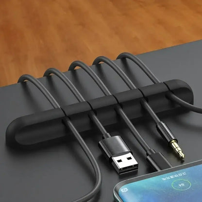 Black silicone USB cable organizer with multiple slots for tidy desktop cable winding