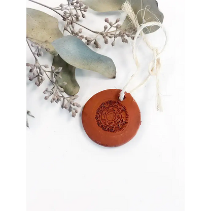 Round terra cotta ornament with mandala design for essential oil diffuser use