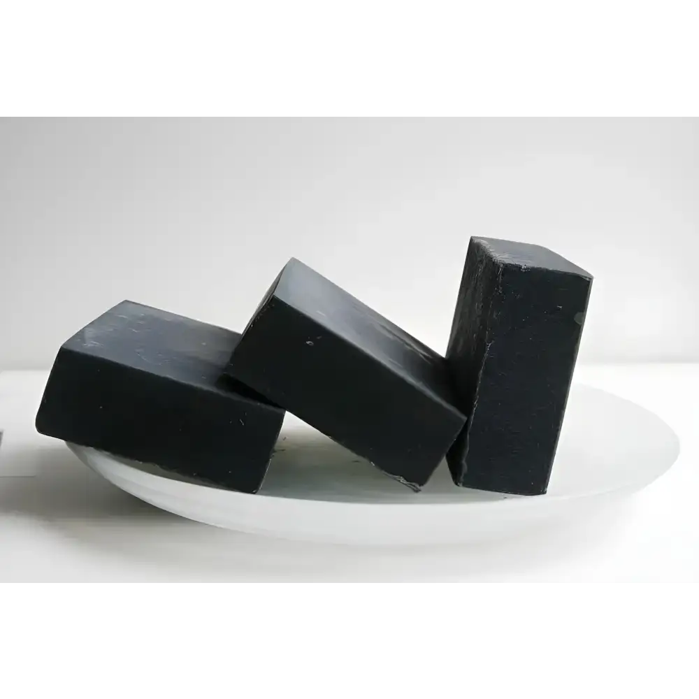 Three black bars of Triple Threat Activated Charcoal Soap, a natural handmade soap