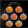 Round wooden aroma diffusers with colorful LED lights.