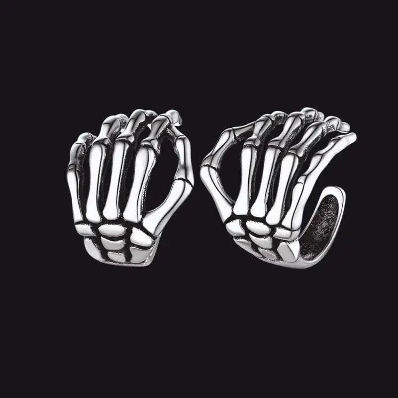Two silver skeleton hand rings.